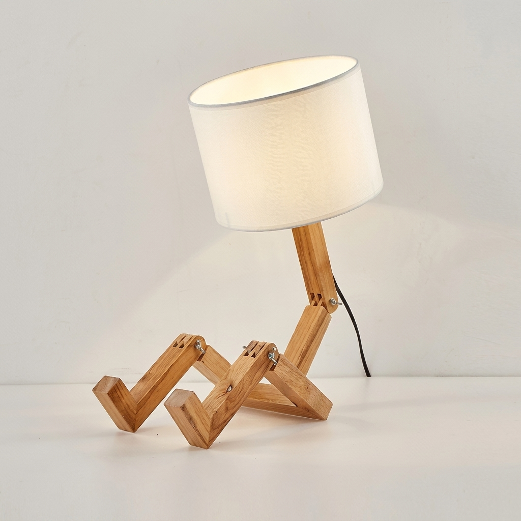 Table lamp with wooden base and white fabric shade on a plain background