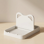 White kitchen dish drainer with handle on a beige surface