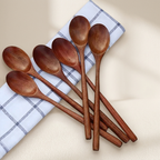 Set of wooden spoons on a checkered cloth with a beige background