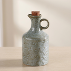 Stoneware bottle with cork stopper on a neutral background