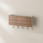 A rectangular wall-mounted coat rack with a woodgrain front panel and five white hooks below, shown mounted on a plain beige wall.
