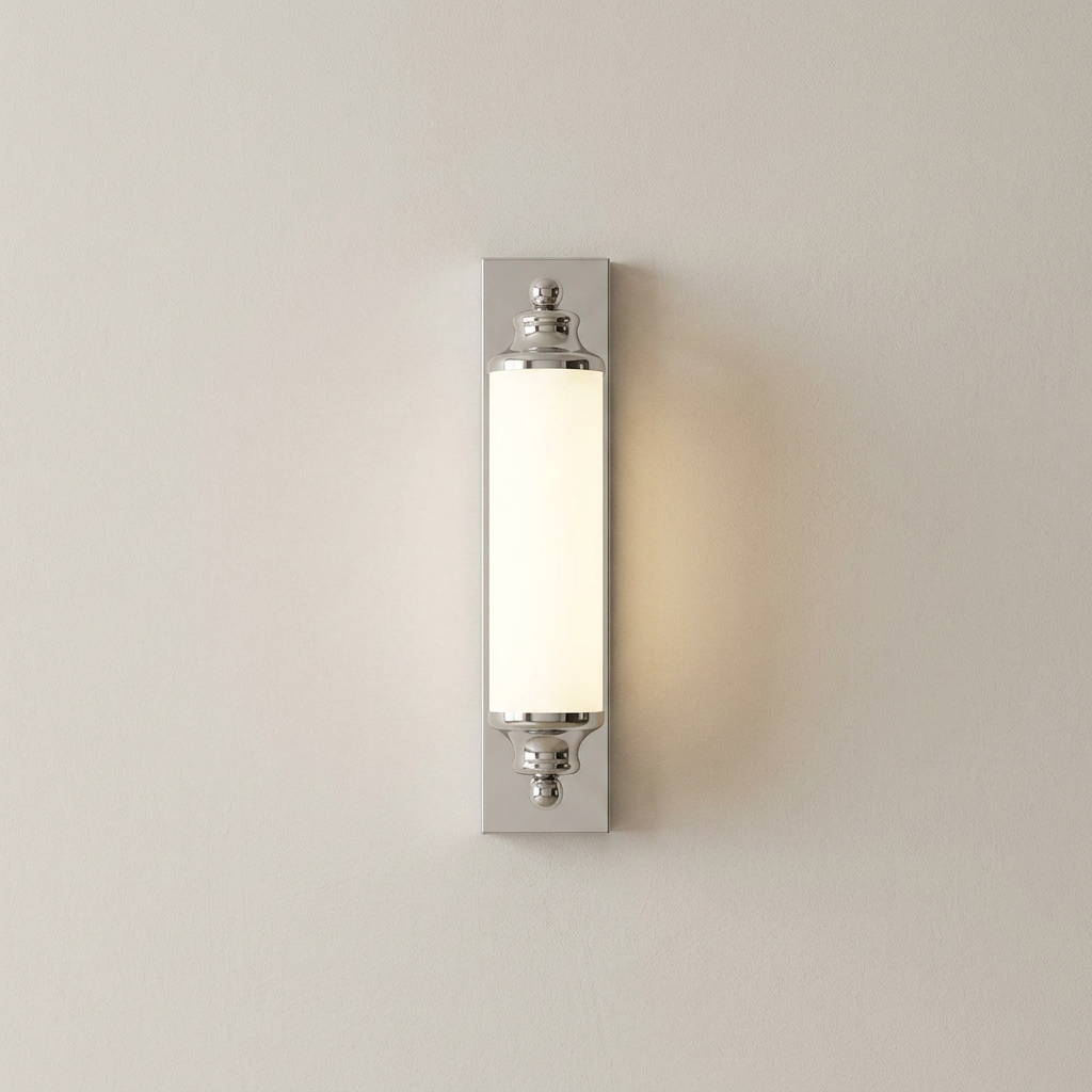 A modern wall-mounted light fixture with a vertical rectangular frosted glass shade and polished silver metal mounting brackets, shown illuminated against a plain off-white wall.