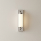 A modern wall-mounted light fixture with a vertical rectangular frosted glass shade and polished silver metal mounting brackets, shown illuminated against a plain off-white wall.