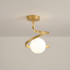 A modern semi-flush mount ceiling light fixture with a brushed gold spiral metal frame and a glowing white frosted glass globe, shown against a neutral off-white ceiling.