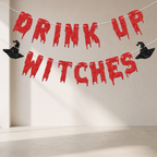 Halloween party banner reading 'DRINK UP WITCHES' in red glittery dripping letters, with two black glitter witch hats hanging on either side, strung against a plain beige wall.