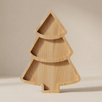 A light natural wood three-tiered tray shaped like a Christmas tree, set against a neutral beige background.