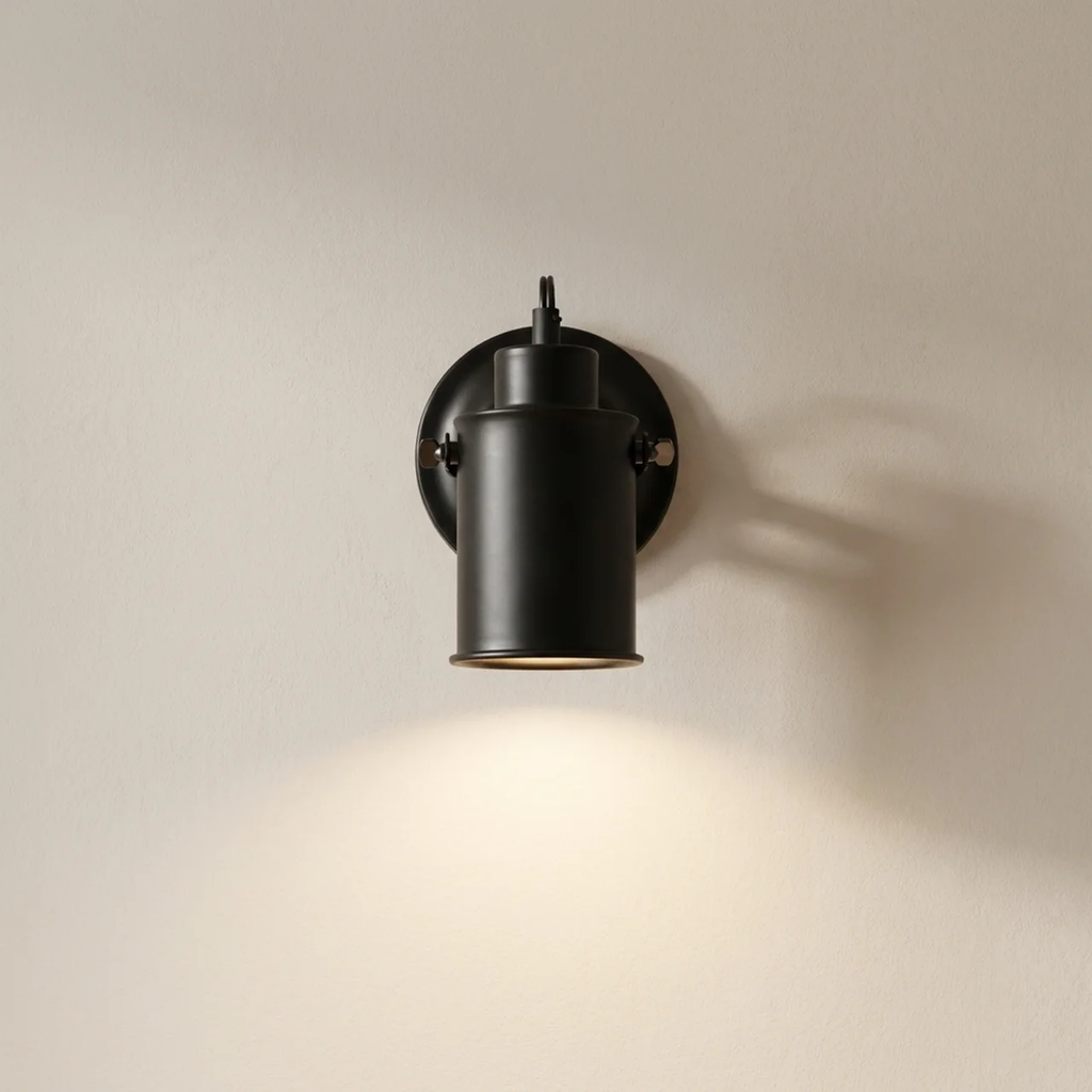 Black wall-mounted light fixture on a beige wall