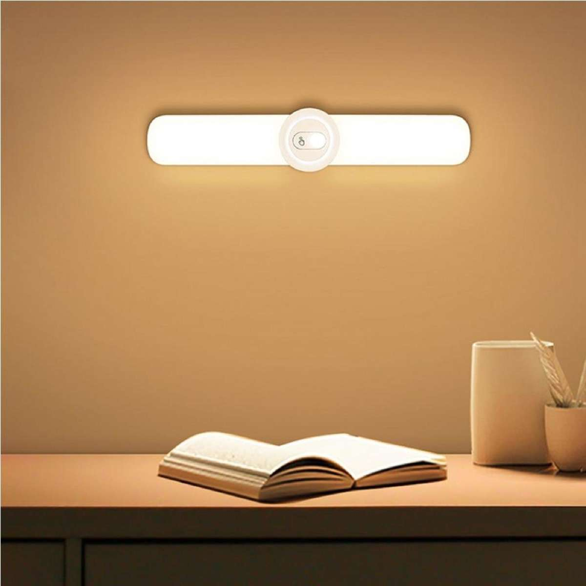 Wall-mounted light fixture on a wall with a table and book in the foreground