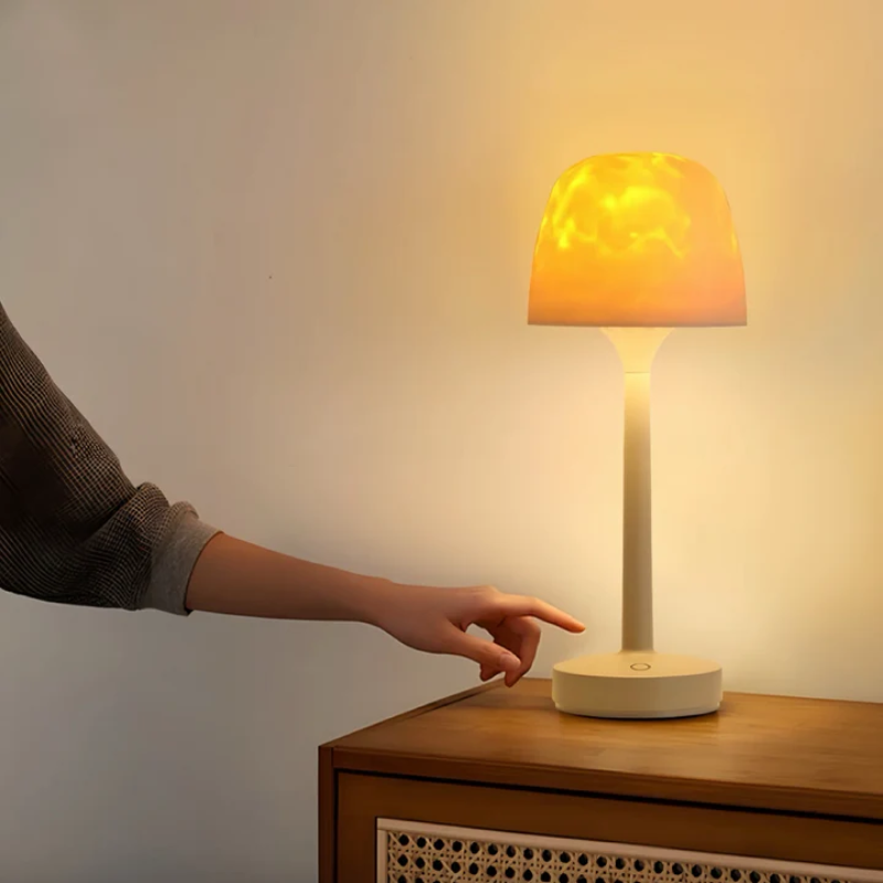 Person turning on a table lamp with a warm glow