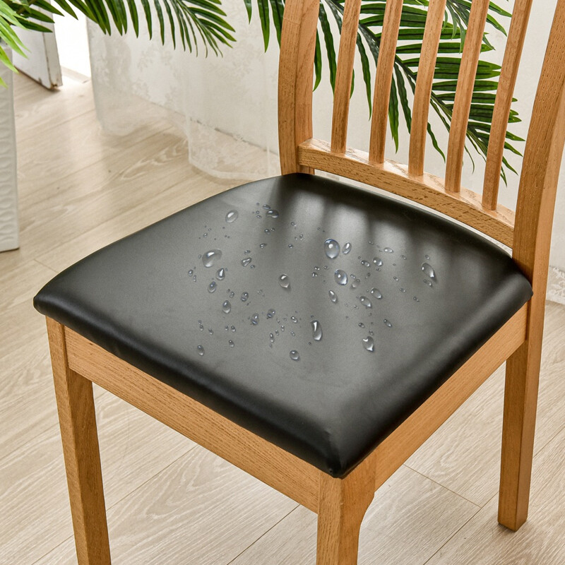 Wooden chair with a black cushion showing water droplets on a light wooden floor.