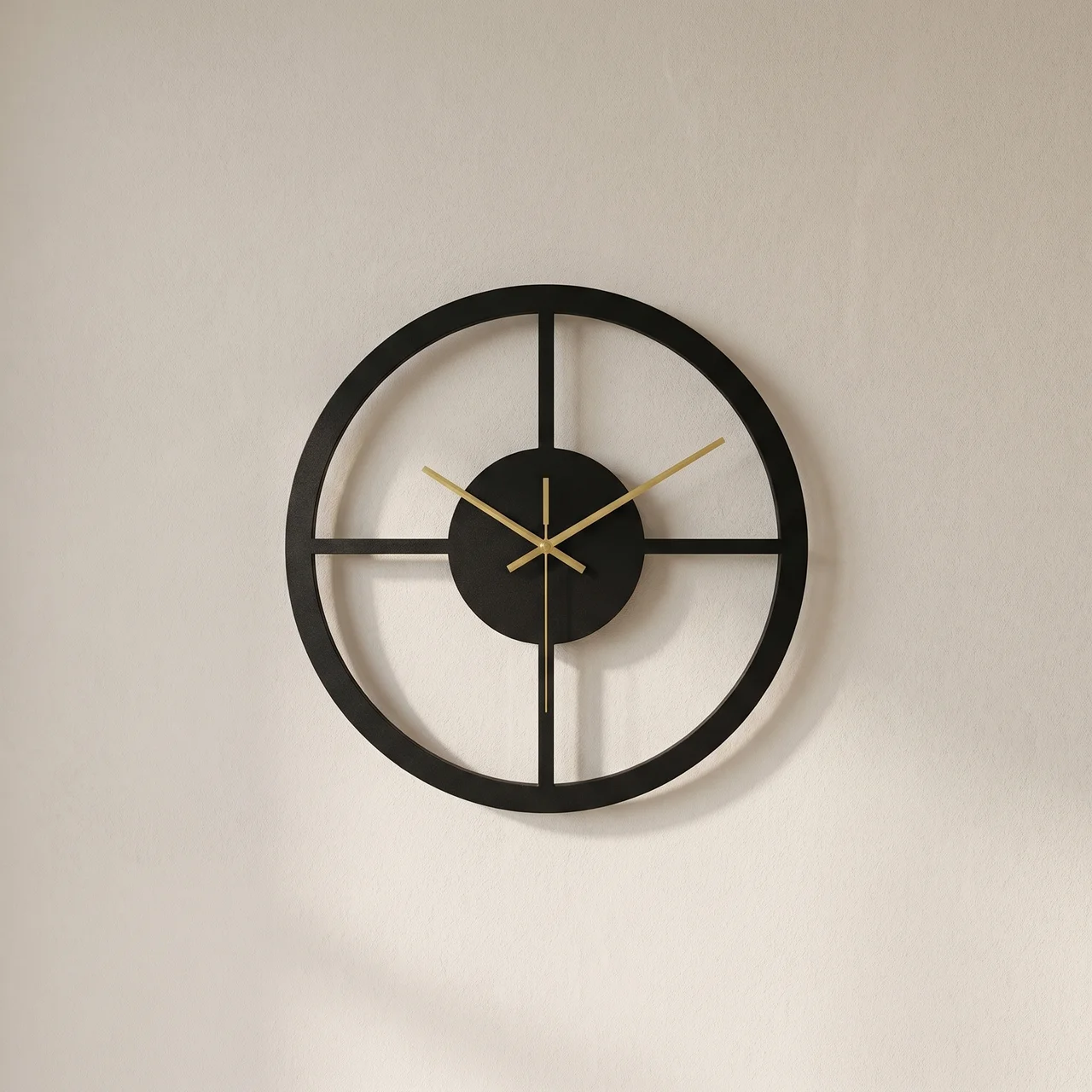 Black wall clock with gold hands on a beige wall
