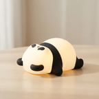 Panda-shaped night light on a wooden surface with a neutral background