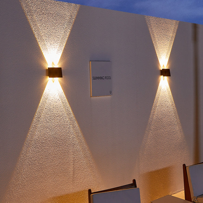 Wall-mounted outdoor light fixture on a textured wall with 'Swimming Pool' sign.