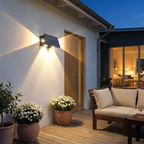 Outdoor patio area with a wall light fixture, potted plants, and a wooden bench.