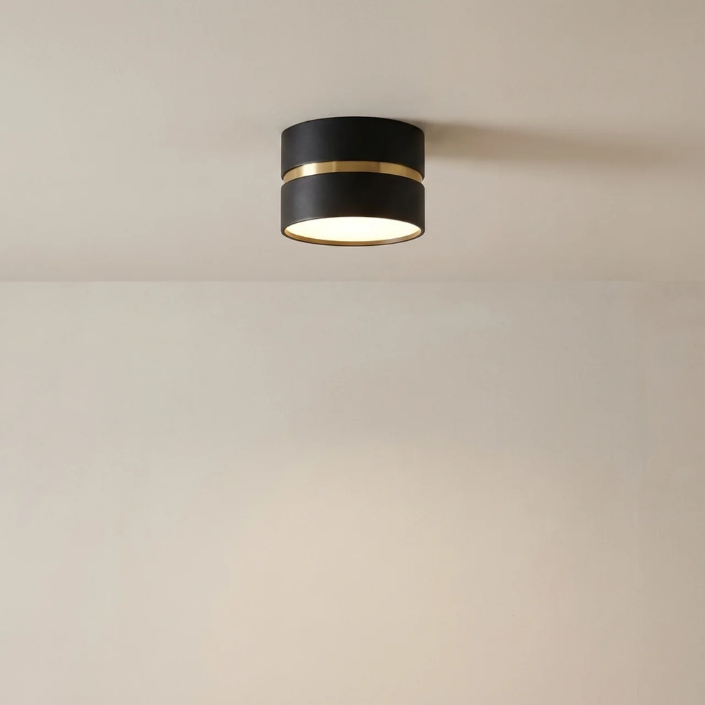 Modern ceiling light fixture with black and gold design on a neutral background