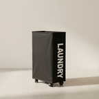 Black laundry basket with 'LAUNDRY' text on a beige background