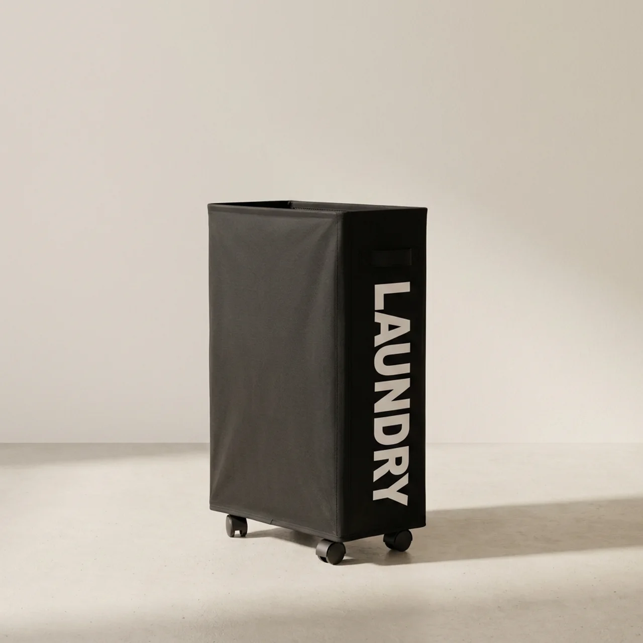 Black laundry basket with 'LAUNDRY' text on a beige background