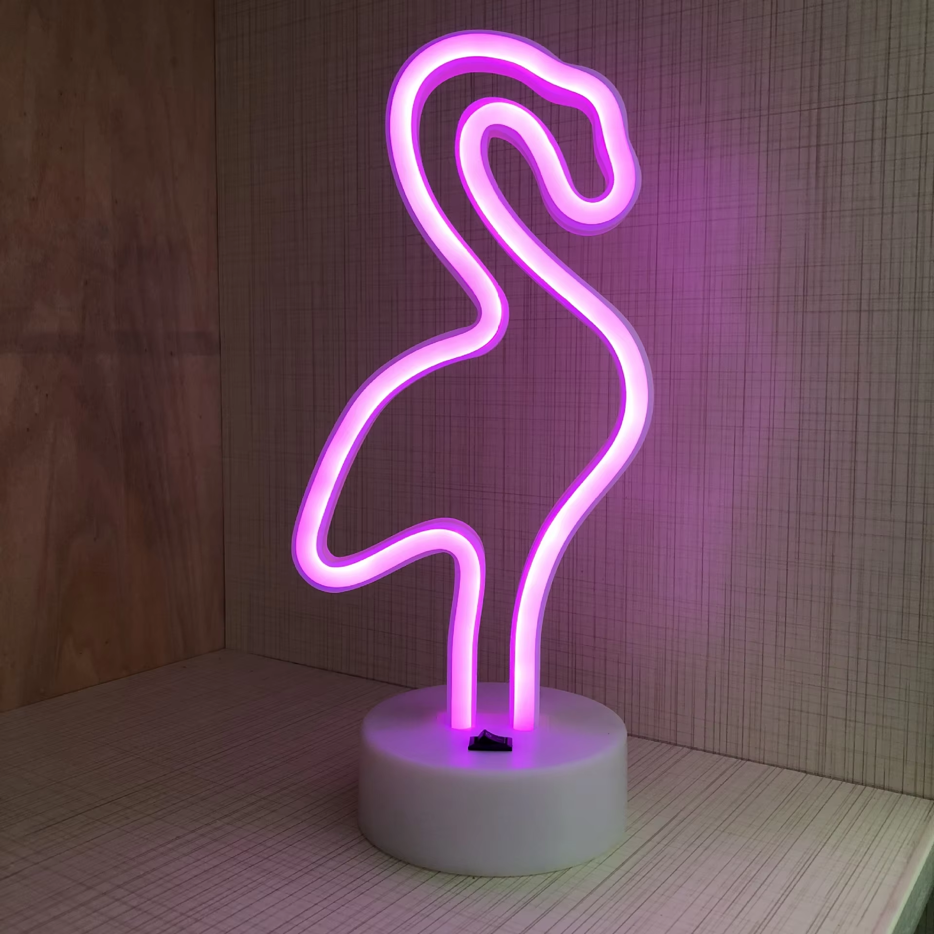 Neon flamingo light on a wooden background
