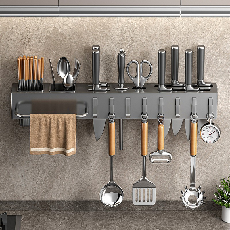 Wall-mounted kitchen utensil holder with various tools on a neutral wall background