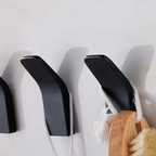 Set of black shoe trees and a wooden brush against a white background