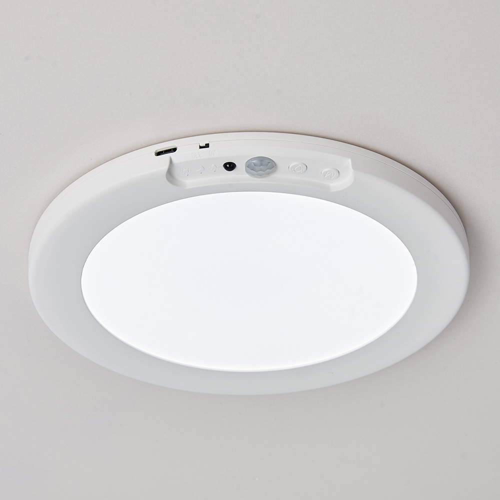 Round ceiling light fixture with sensor on a white ceiling