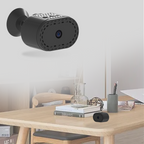 Small black camera on a wooden table with text indicating its use as an indoor camera.
