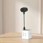 Small camera attached to a white cube on a wooden surface with a beige background