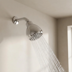 Chrome shower head with water flowing in a bathroom setting