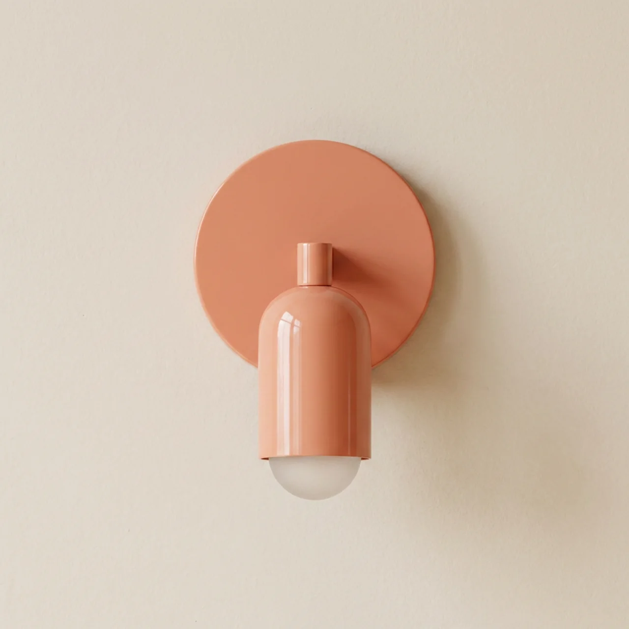 Coral-colored wall sconce on a beige wall