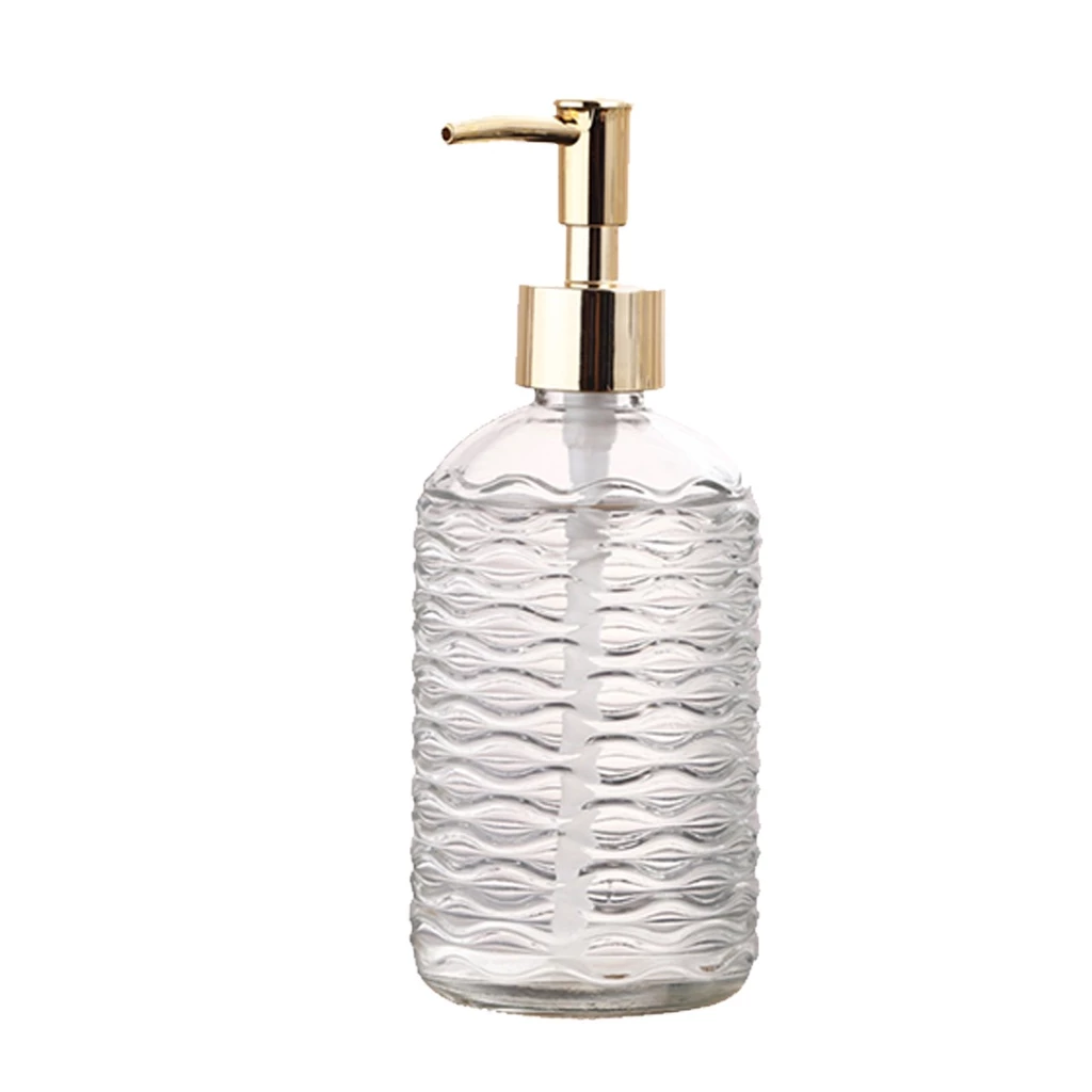 Clear glass soap dispenser with gold pump on a white background
