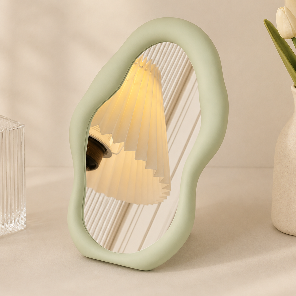 Decorative mirror with a soft green frame on a neutral background