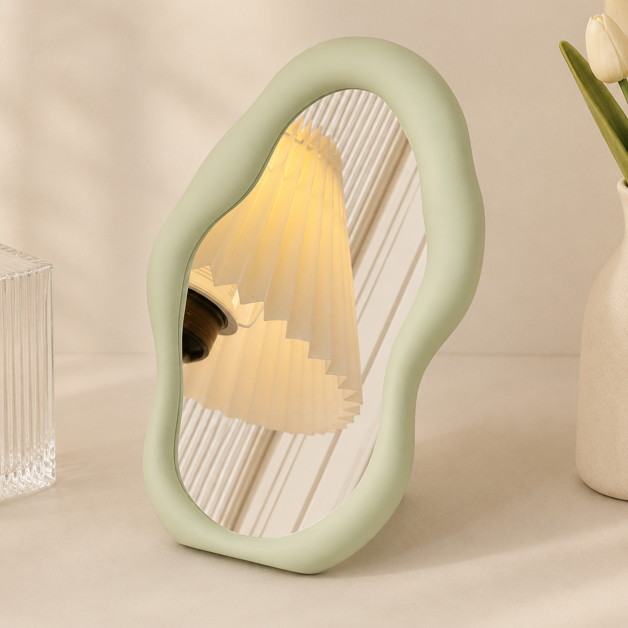 Decorative mirror with a soft green frame on a neutral background