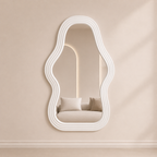 Wave-shaped mirror with wavy white frame on a beige wall