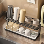 Kitchen countertop with a black metal rack holding various cups and containers.