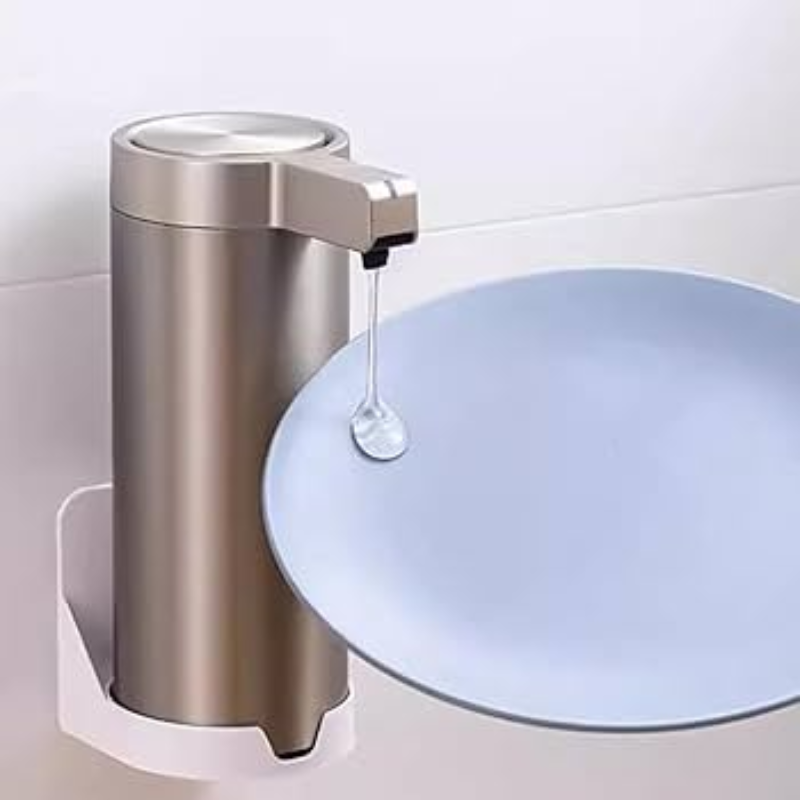 Hand soap dispenser on a white wall with soap being dispensed onto a blue dish.