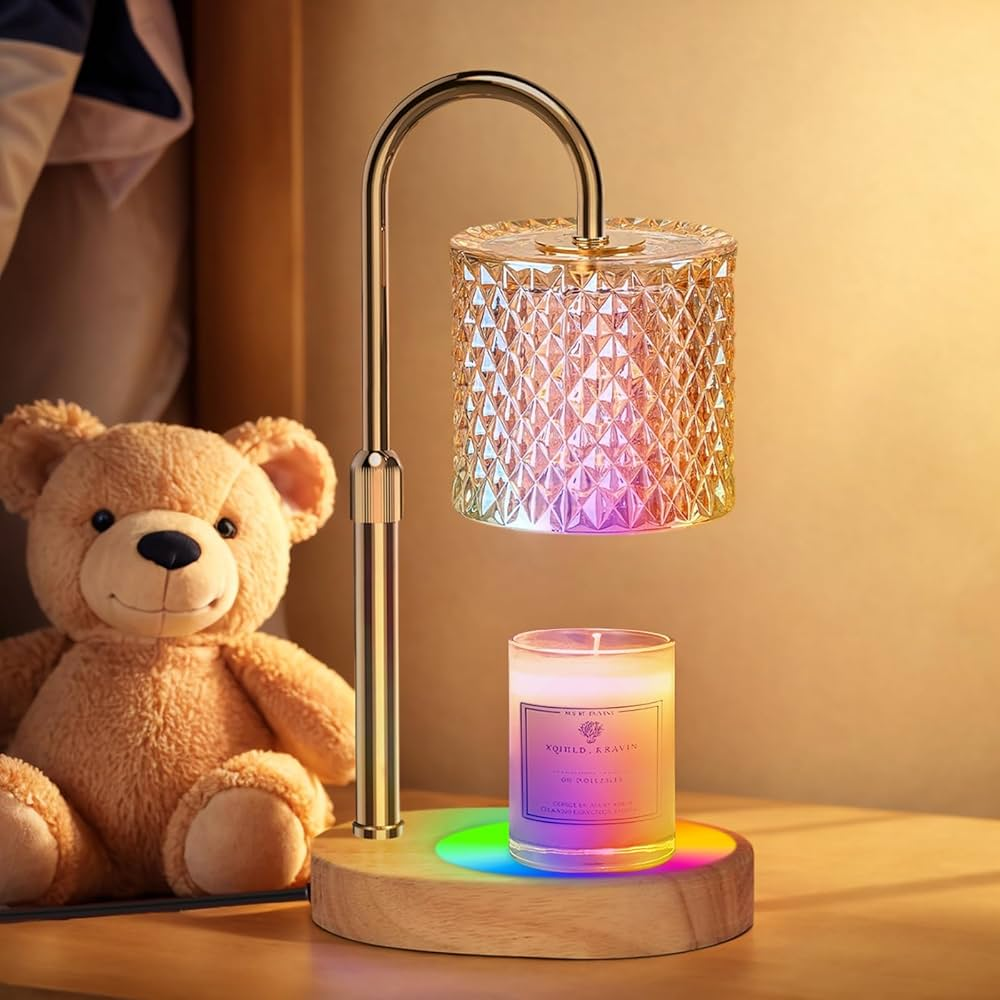 Decorative lamp with colorful light, candle, and teddy bear on a wooden surface.