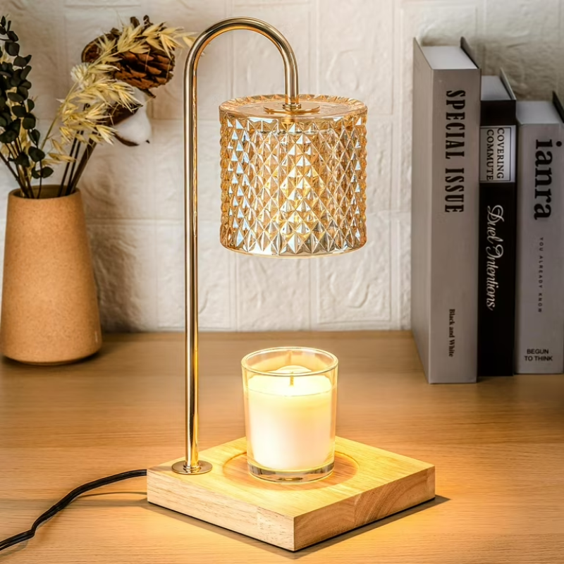 Decorative lamp with a candle on a wooden base, next to books and a vase with plants.