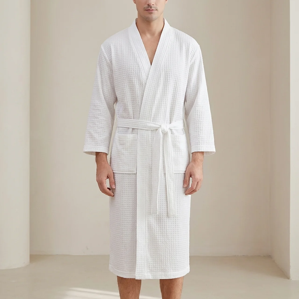 Person wearing a white textured bathrobe in a minimalistic setting