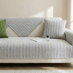 Gray patterned sofa with a green pillow in a living room setting