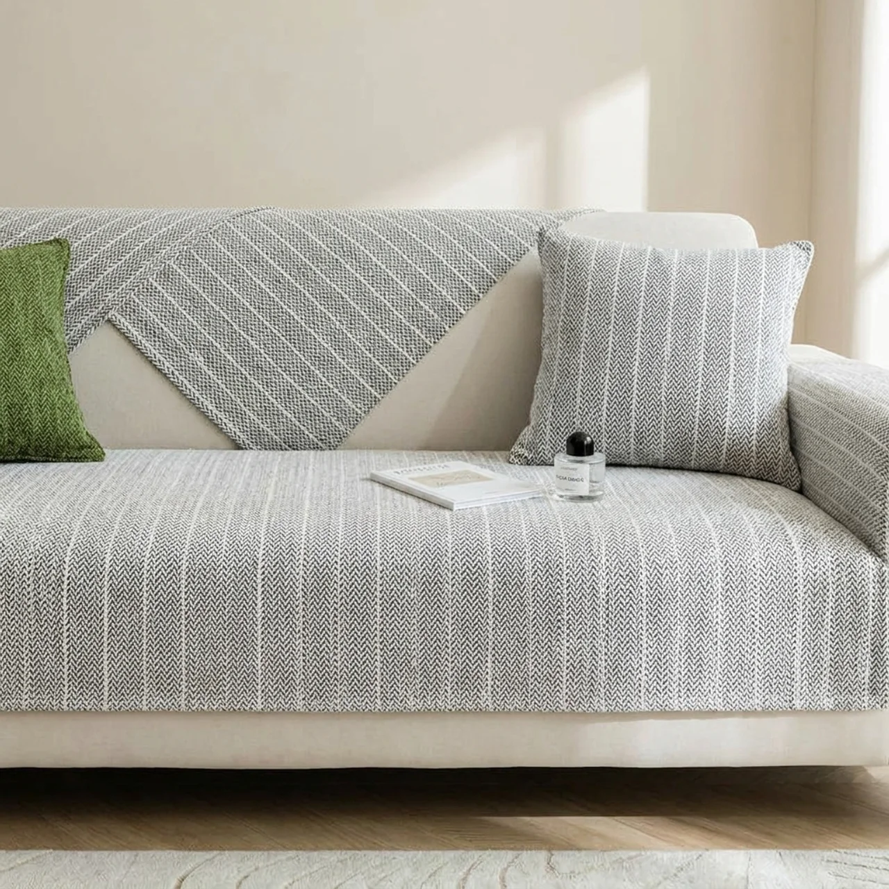 Gray patterned sofa with a green pillow in a living room setting