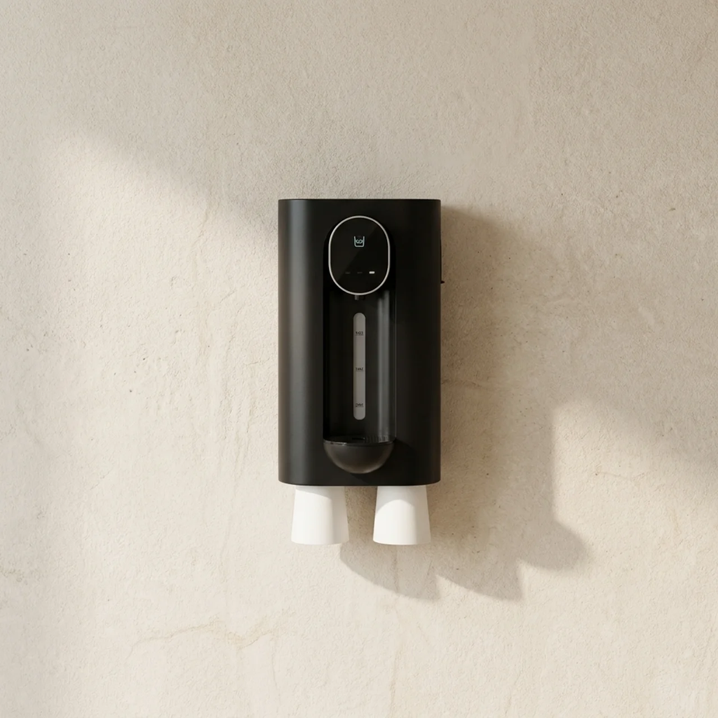 Black wall-mounted device with two white nozzles on a beige wall