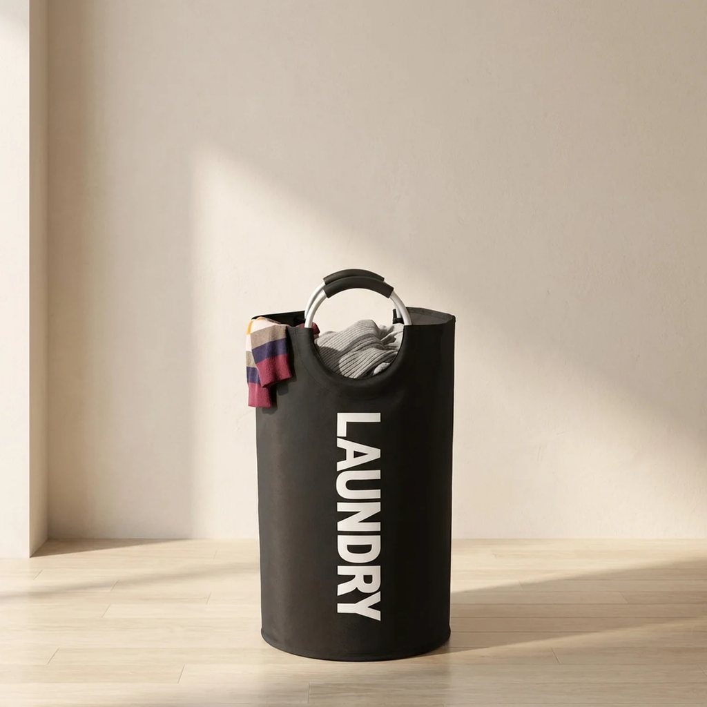 Black laundry basket with 'LAUNDRY' text on a wooden floor.