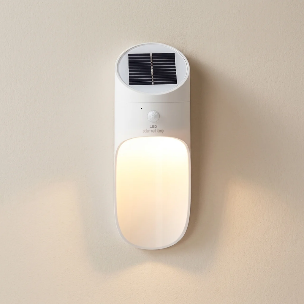White solar-powered outdoor light fixture on a beige wall