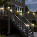 Staircase leading to a house with string lights on the railings at night.