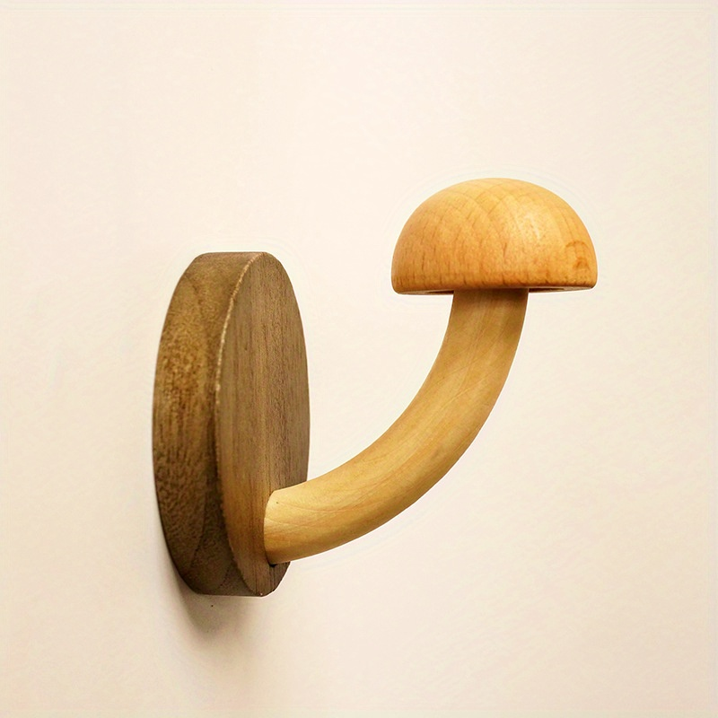 Wooden mushroom-shaped hook on a beige background