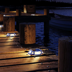 Dock lights on a wooden dock by a body of water with text 'Keep Brilliant on Dock All Year Round'.