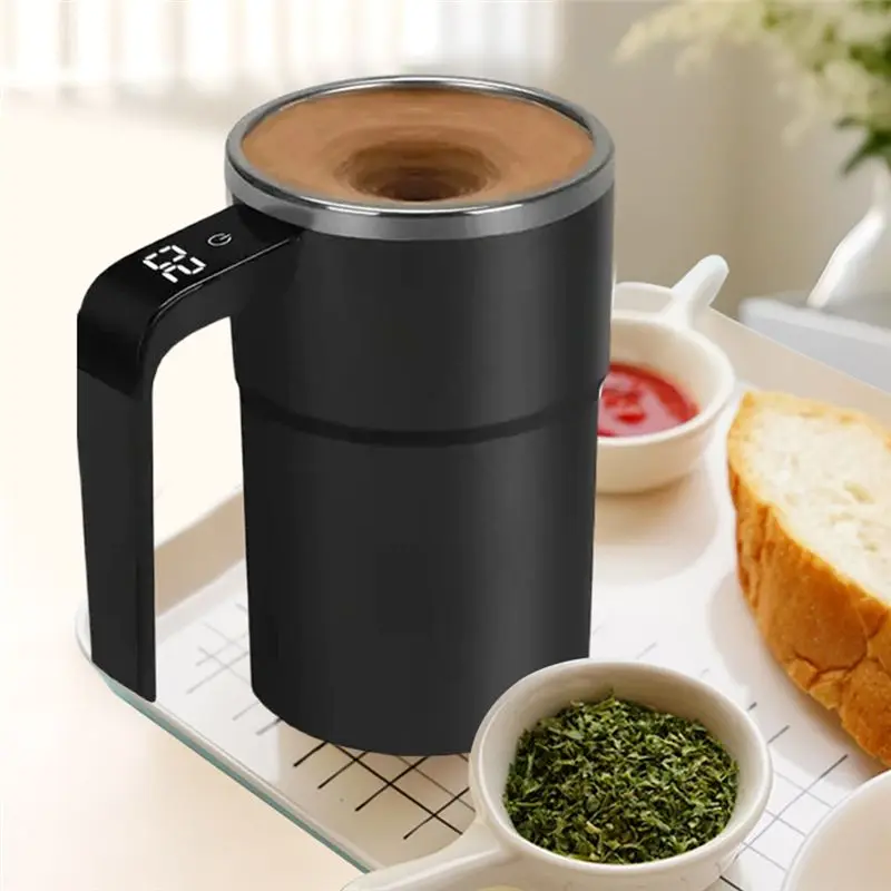 Black electric coffee maker on a kitchen counter with bread and bowls of ingredients.