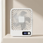 A compact white portable fan with a digital display showing 100% battery, placed on a light beige surface against a warm beige background.