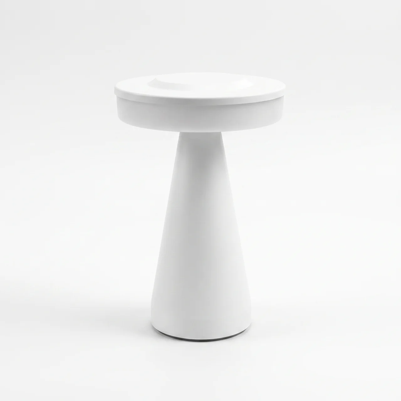 A minimalist white side table with a circular top and a tapered cone-shaped base, photographed on a seamless white background.