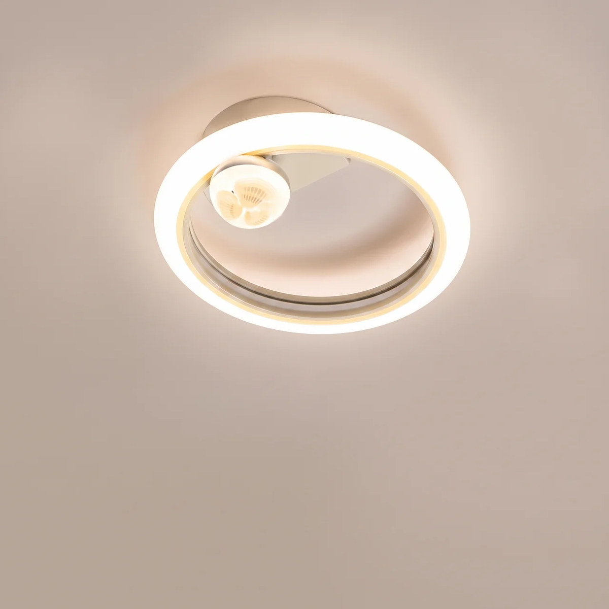 A modern flush-mount ceiling light fixture with a double-ring design, featuring a warm white illuminated LED ring and a central bulb, mounted on a plain beige ceiling.